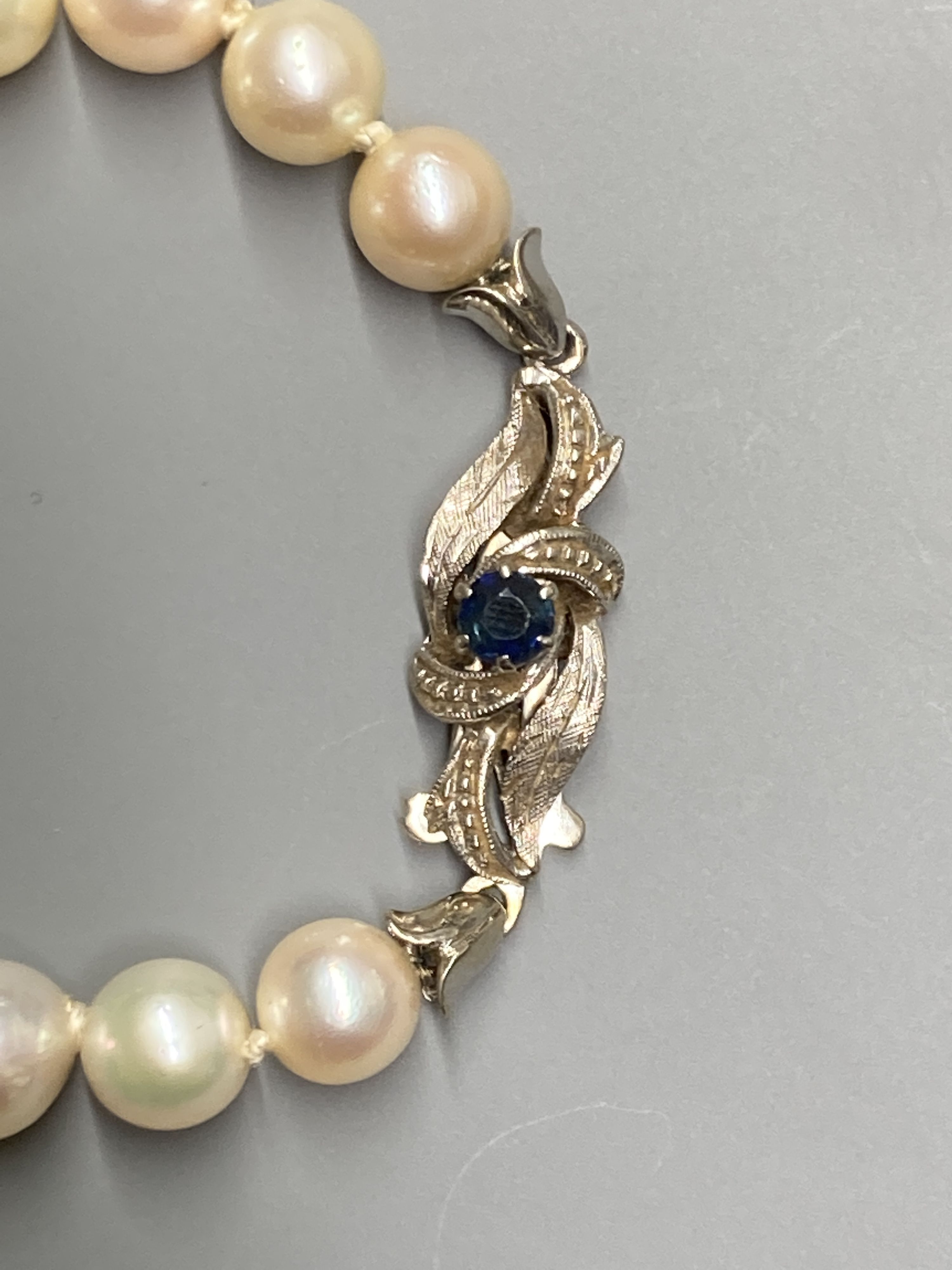 A single strand cultured pearl choker necklace, with 18ct white gold and sapphire set clasp, a 14ct and smoky quartz pendant, gross 17.8 grams, two 925 chains and a 750 small pendant(a.f.) on a gilt metal chain.